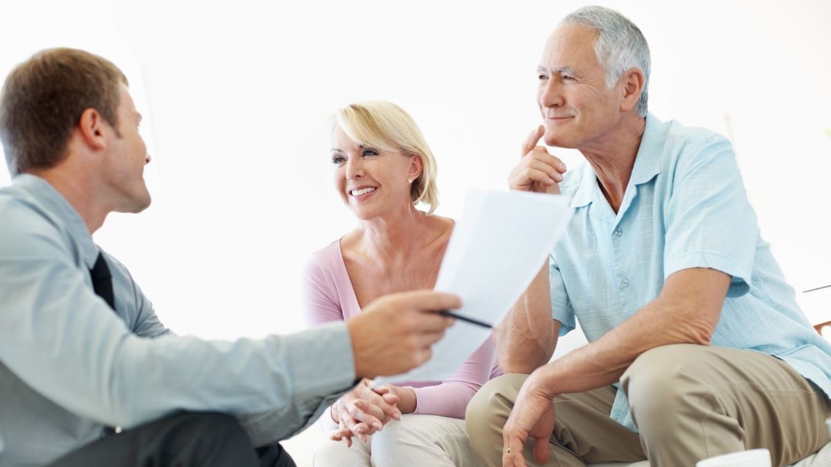 Senior couple discussing Medicare Advantage Plans with an advisor in a bright office setting.