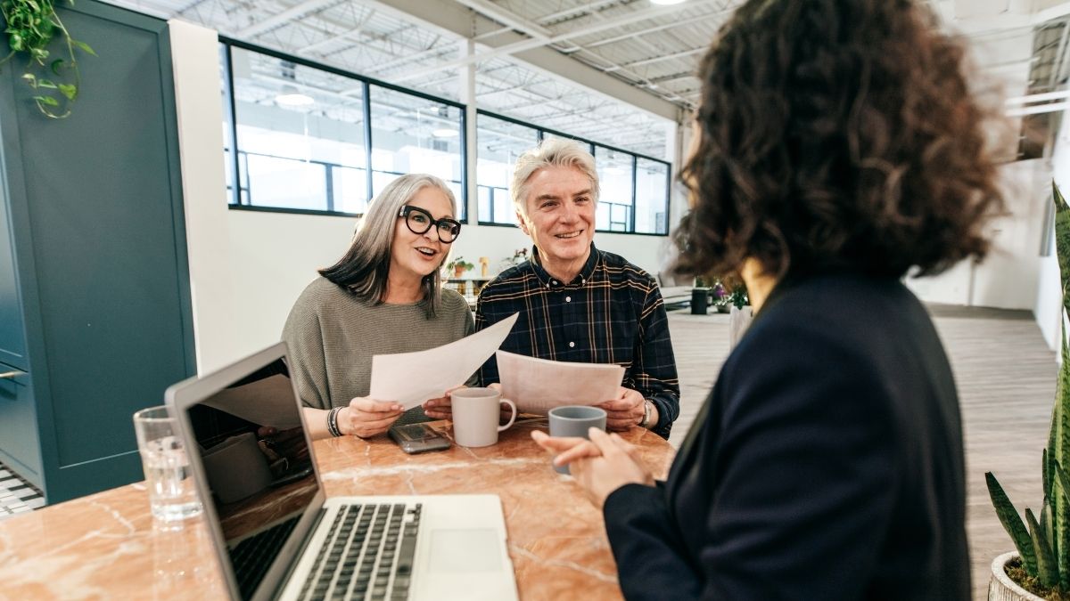 Senior couple reviewing documents with an insurance agent, discussing what is the best Medicare supplement insurance plan for their needs.
