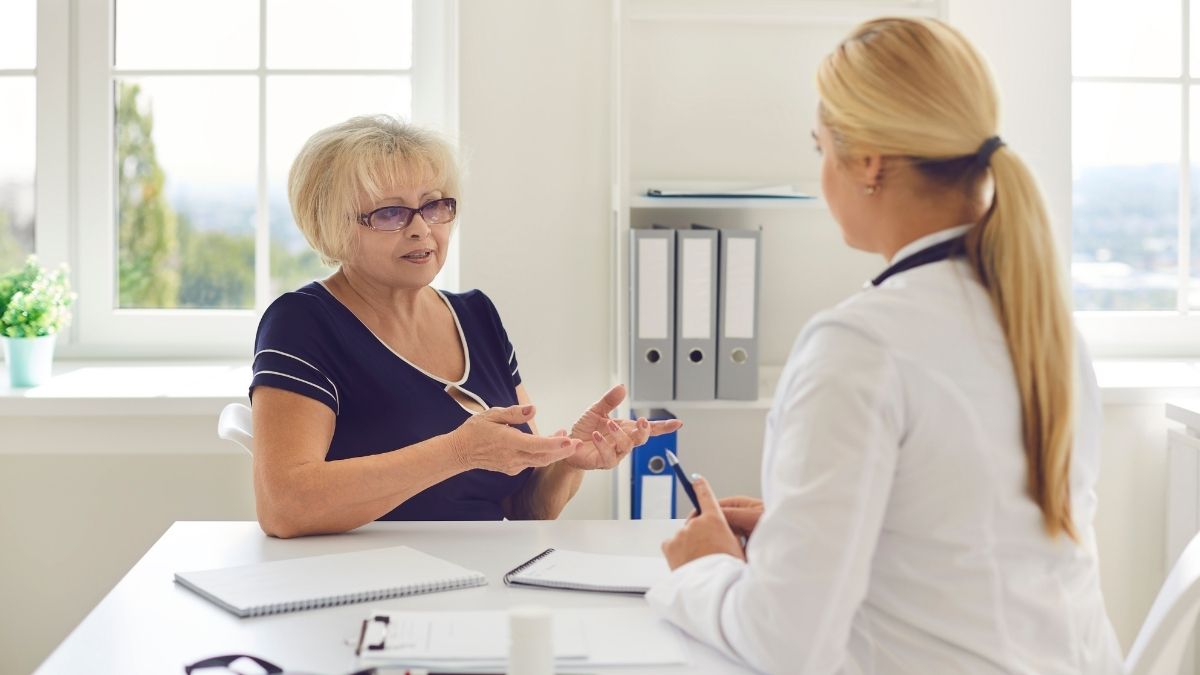 Senior woman discussing prescription coverage options with a healthcare professional during Medicare Part D enrollment.