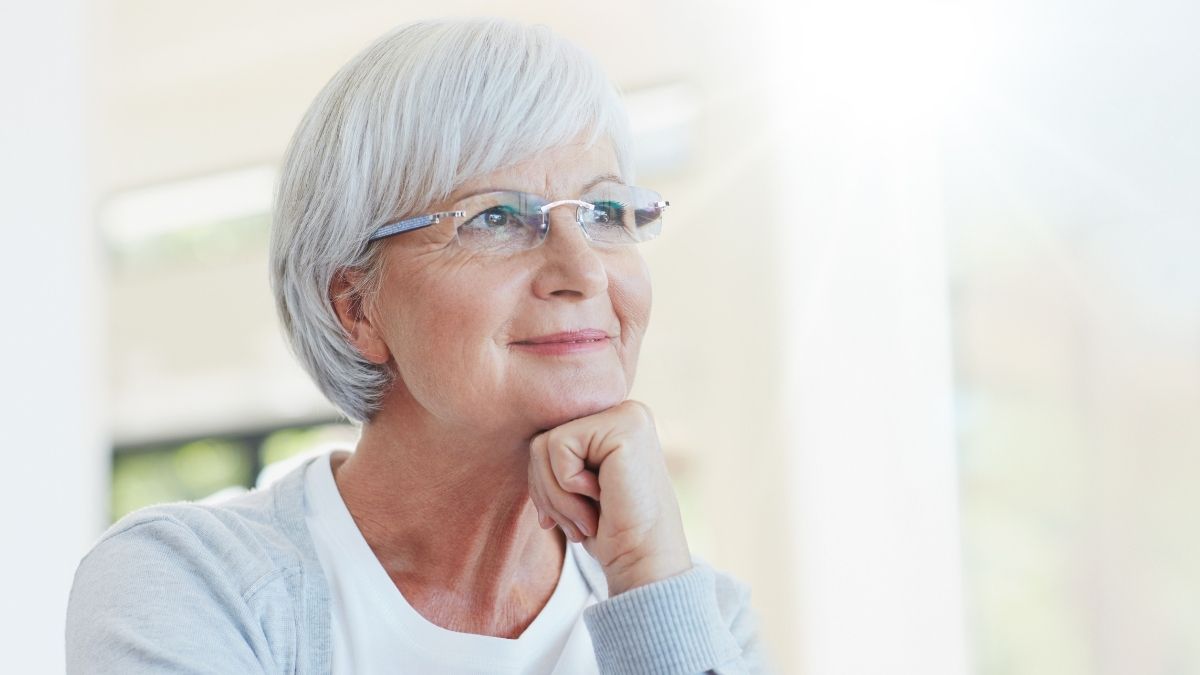Smiling senior woman wearing glasses, looking thoughtful, representing the topic ‘What are Medicare supplement plans'.